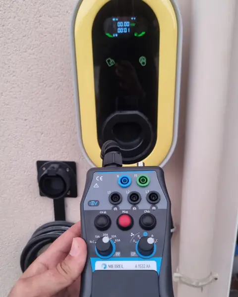 Adaptateur de test branché devant une borne murale à écran