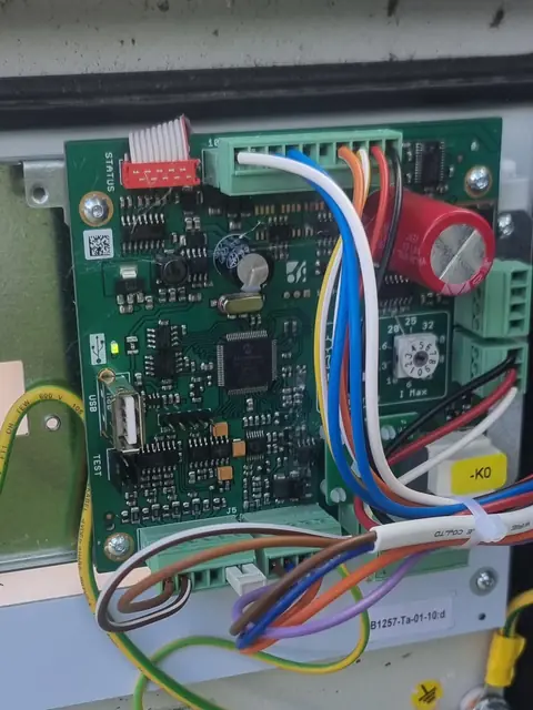 Porte ouverte d’une borne sur pied : carte électronique et câblage.